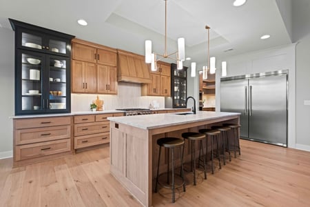 Image of a remodeled kitchen in Overland Park, Kansas, with an island-centric design and chandeliers