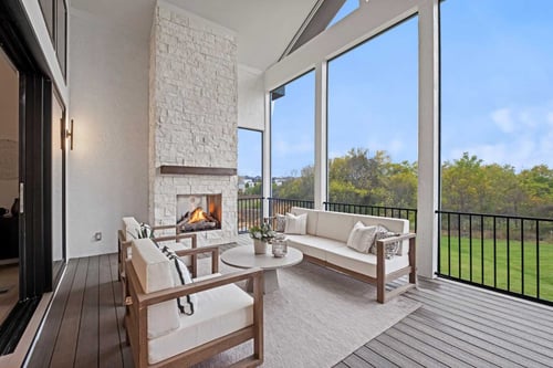 Image of a covered patio attached to a single family, custom-built home in Overland Park, Kansas, with large windows facing a big backyard.