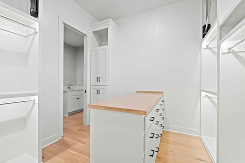 Image of a spacious, remodeled walk-in closet in Overland Park, Kansas, with a storage island