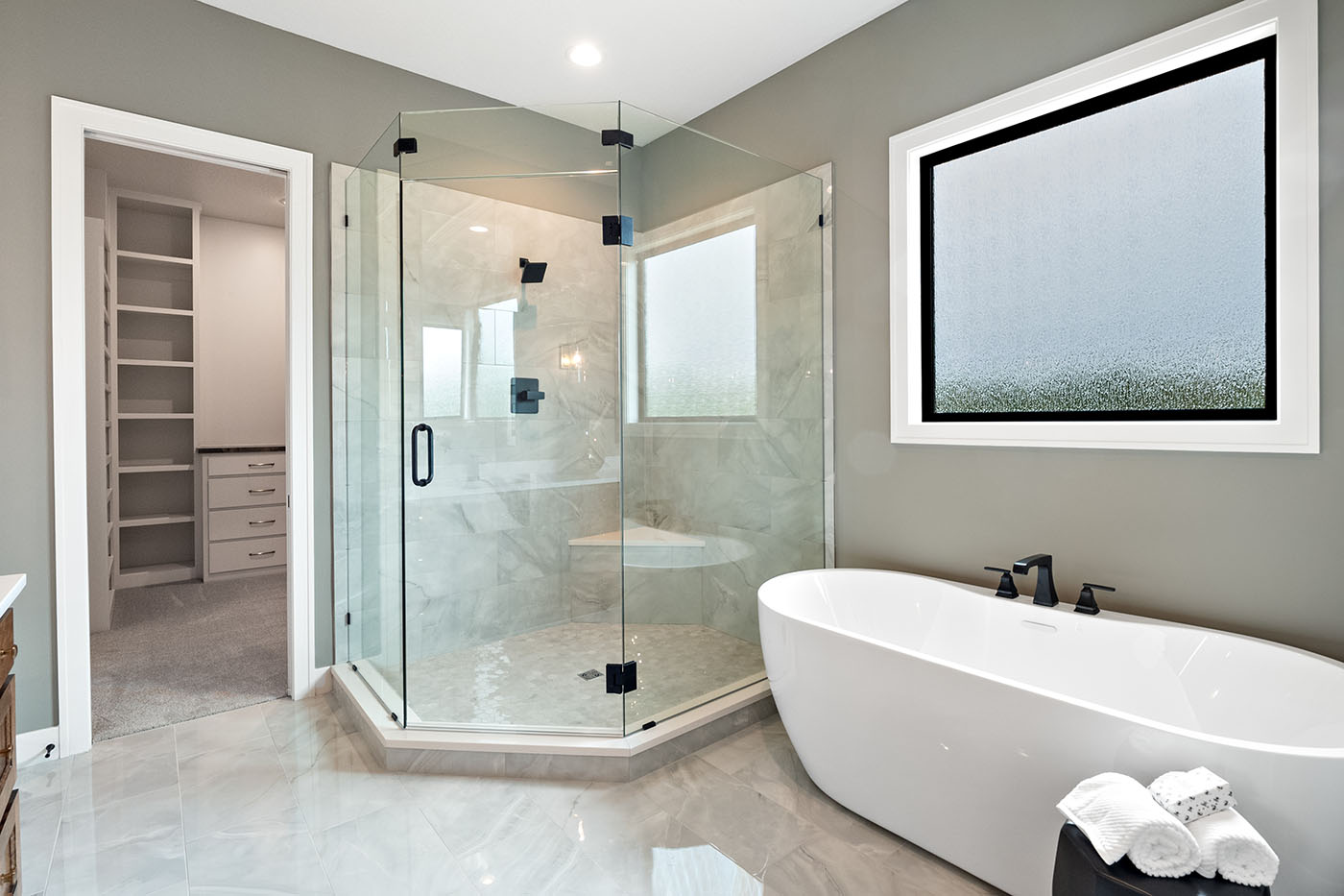 Primary bathroom with a garden tub and spacious walk-in glass shower in a custom home built by Dusty Rhodes Homes in Overland Park, Kansas. Primary bathroom with a garden tub and spacious walk-in glass shower in a custom home built by Dusty Rhodes Homes in Overland Park, Kansas.